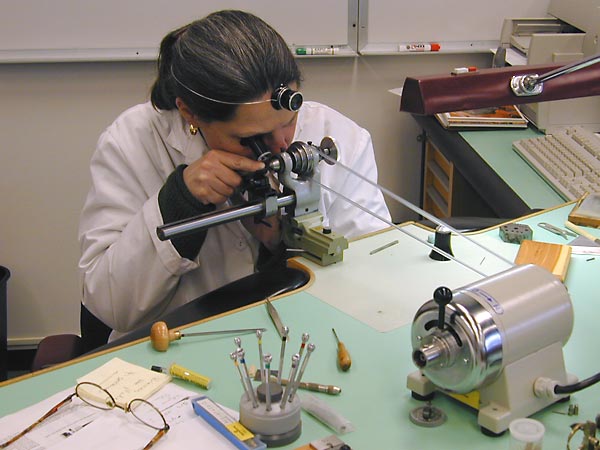 A watchmaker finishing a movement by hand